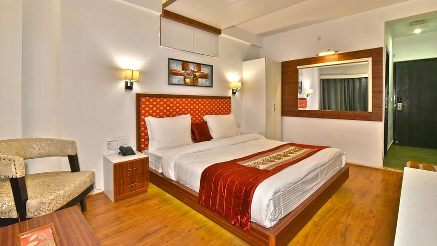 Side view of the bedroom with two warm lights on each side at DLS Hillcrest Resort, Shimla.